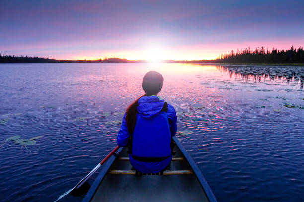 istock Young female in canoe on the lake with sunset 1040574148