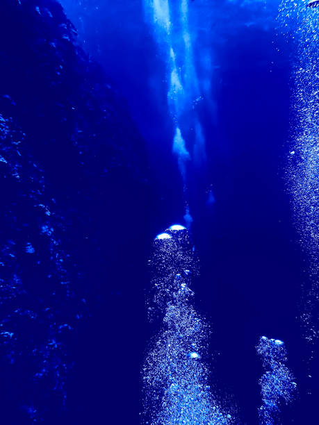 istock Rows of Bubbles Rise from Divers Underwater in Blue 1040578956