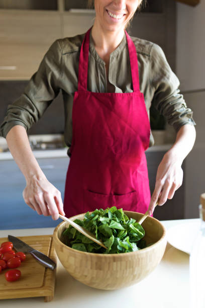 istock Young woman preparing salad in the kitchen. 1040579660