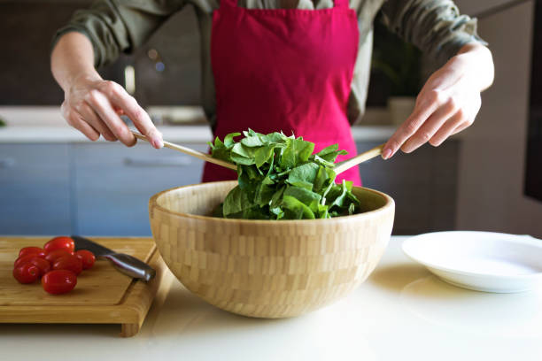 istock Young woman preparing salad in the kitchen. 1040580212