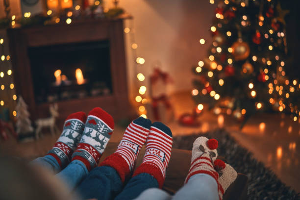 bambini carini in calze natalizie seduti in un'accogliente atmosfera natalizia - christmas family child christmas tree foto e immagini stock