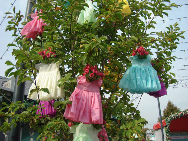 istock Installation with hanging children's dresses on the tree. 1040592148