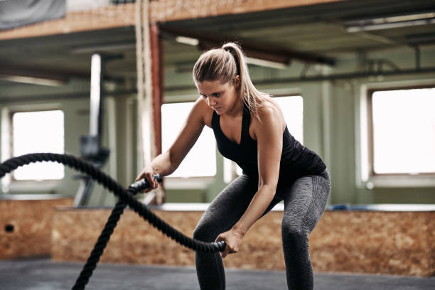istock Fit young woman exercising with ropes during a gym workout 1040608540
