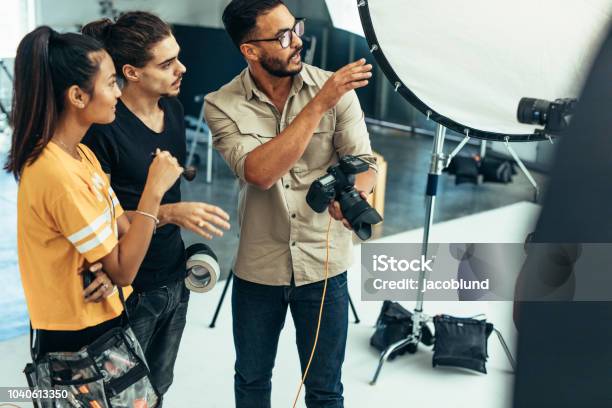 Photo libre de droit de Travaillant Avec Son Équipe Pendant Une Séance Photo Dans Un Studio De Photographe banque d'images et plus d'images libres de droit de Photographe