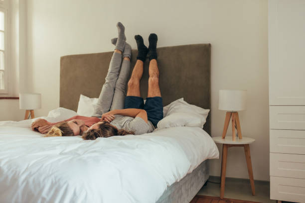 istock Romantic couple lying on bed together with raised legs 1040629294
