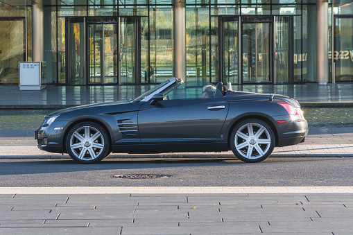 ESSEN, NRW, GERMANY - OCTOBER 11, 2015:
Chrysler Crossfire, side view of the new administrative building of ThyssenKrupp in Essen, Germany.