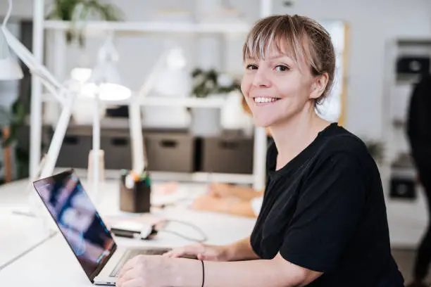 Photo of Portrait of graphic designer in Scandinavia, working on laptop.