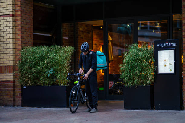 Coventry Town Centre DELIVEROO Currier is setting Navigation for serving food from Restaurant to Customer. Coventry, UK - September 13th, 2018 : Coventry Town Centre DELIVEROO Currier is setting Navigation for serving food from Restaurant to Customer. coventry godiva stock pictures, royalty-free photos & images