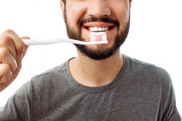 istock Portrait of smiling man with beard, with toothbrush, on isolated white background. 1040670708