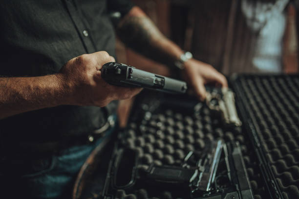 achat d’une arme à feu sur le marché noir - gun men holding handgun photos et images de collection