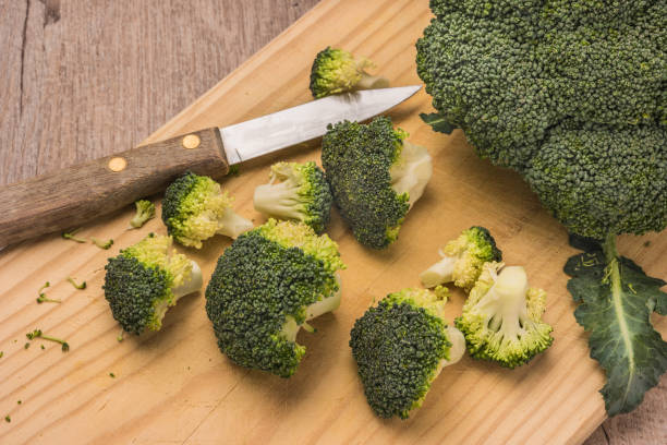 istock Fresh broccoli and knife on wooden table close up 1040675352