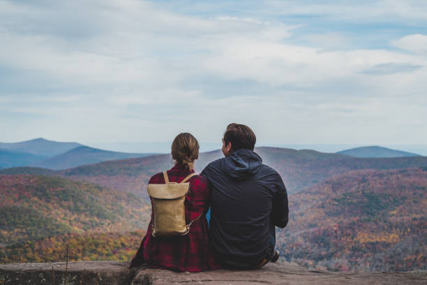 A Young Couple Relaxing in nature in Autumn A beautiful shot of a couple relaxing in nature in autumn when the colors are changing. appalachian mountains photos stock pictures, royalty-free photos & images