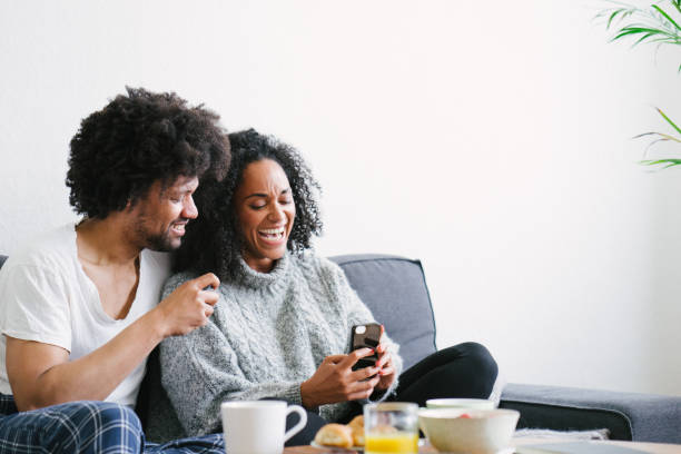 istock Young beautiful couple on sofa using smartphone 1040701566