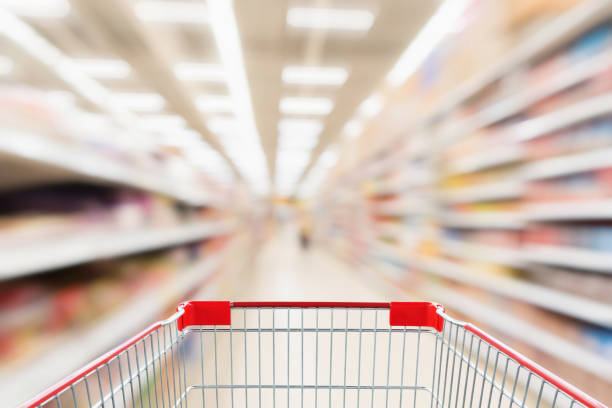 istock Supermarket aisle blurred background with empty red shopping cart 1040704902