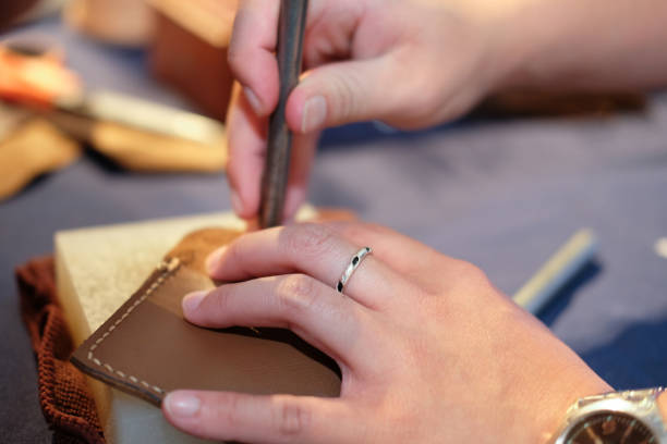 istock craftsman pinching button on leather bag. handmade DIY handicraft 1040705080