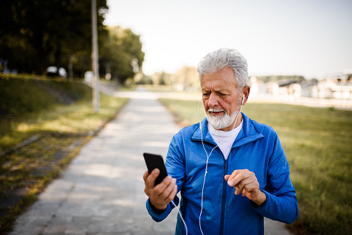 Active senior runner with smart phone.