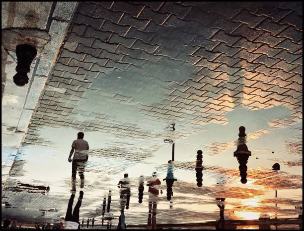 reflection view of people walking after rain on the street at sunset - çanakkale city imagens e fotografias de stock