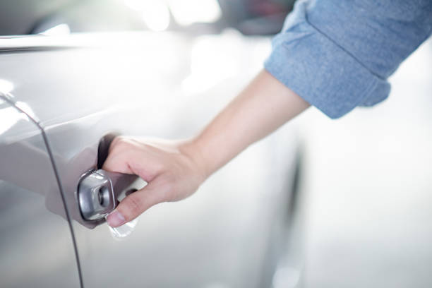 close up of male hand holding and opening the metallic car door handle. urban lifestyle with automobile concept - car car door car key door imagens e fotografias de stock