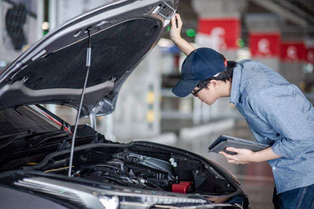 istock Asian auto mechanic holding digital tablet checking car engine under the hood in auto service garage. Mechanical maintenance engineer working in automotive industry. Automobile servicing and repair 1040774348