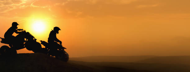 silhueta atv ou quad motos pular no pôr do sol. - off road vehicle quadbike motocross desert - fotografias e filmes do acervo