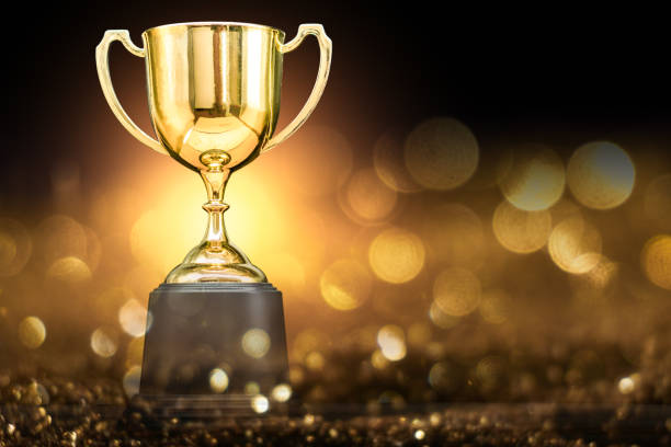 trophy over wooden table and dark background - gold medal medal winning trophy imagens e fotografias de stock