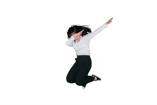 Attractive young businesswoman dancing and jumping in the studio, isolated on white background