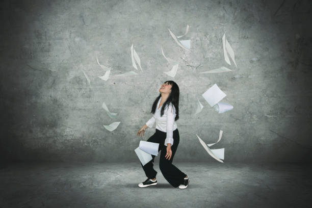 istock Cheerful businesswoman throwing documents 1040813594
