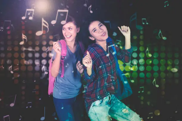 Portrait of female college students celebrating their success by dancing together