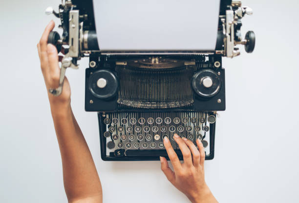 scriviamo una storia - machine typewriter human hand typing foto e immagini stock