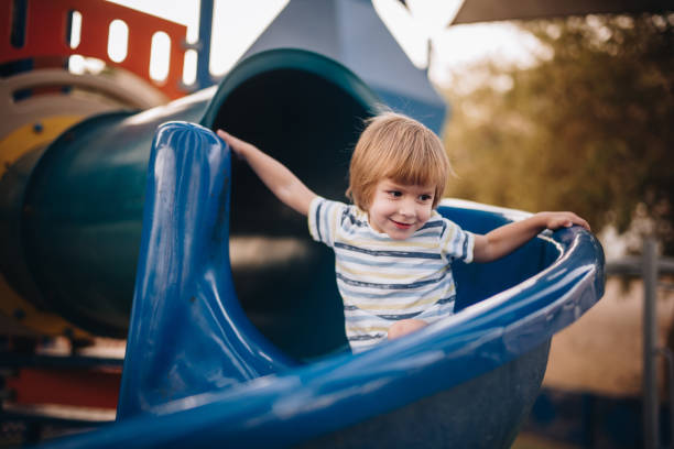 istock Cute small kid sliding on playground in the park. 1040853004
