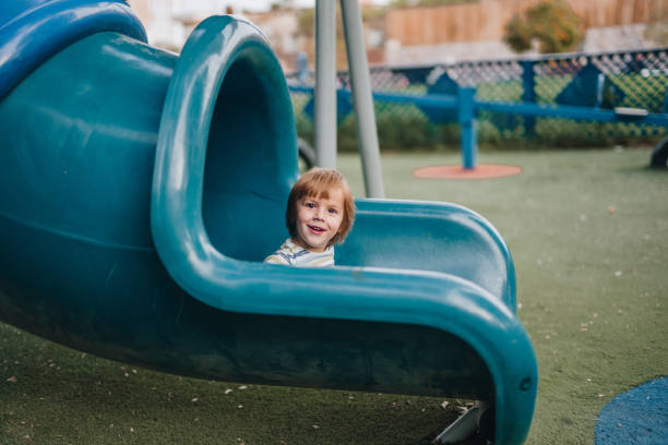 istock Smiling kid having fun while sliding on the playground. 1040853186