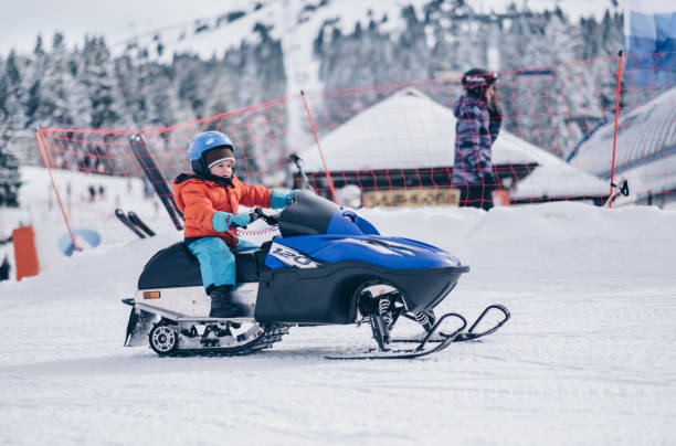 istock Small boy riding snowmobile during winter holiday. 1040853406