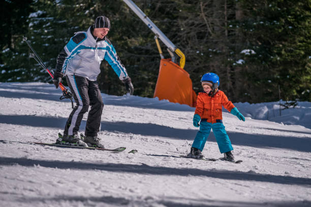 istock Happy father and son skiing together during winter holiday. 1040853480