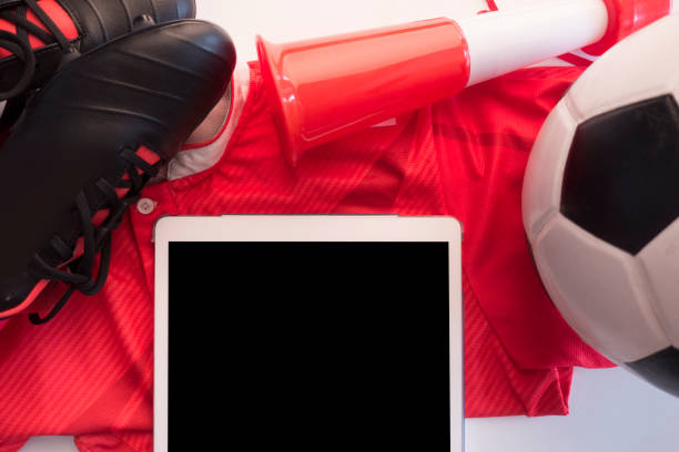 istock Soccer ball, cleats,on red background. Studio shot .Flat lay, top view 1040860074