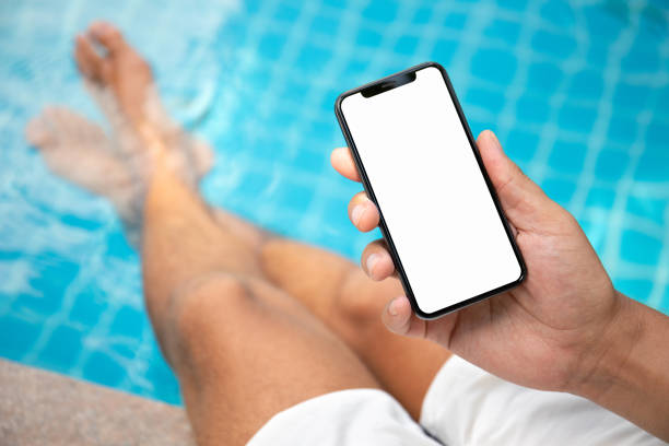 istock man at the pool holding phone with an isolated screen 1040867886