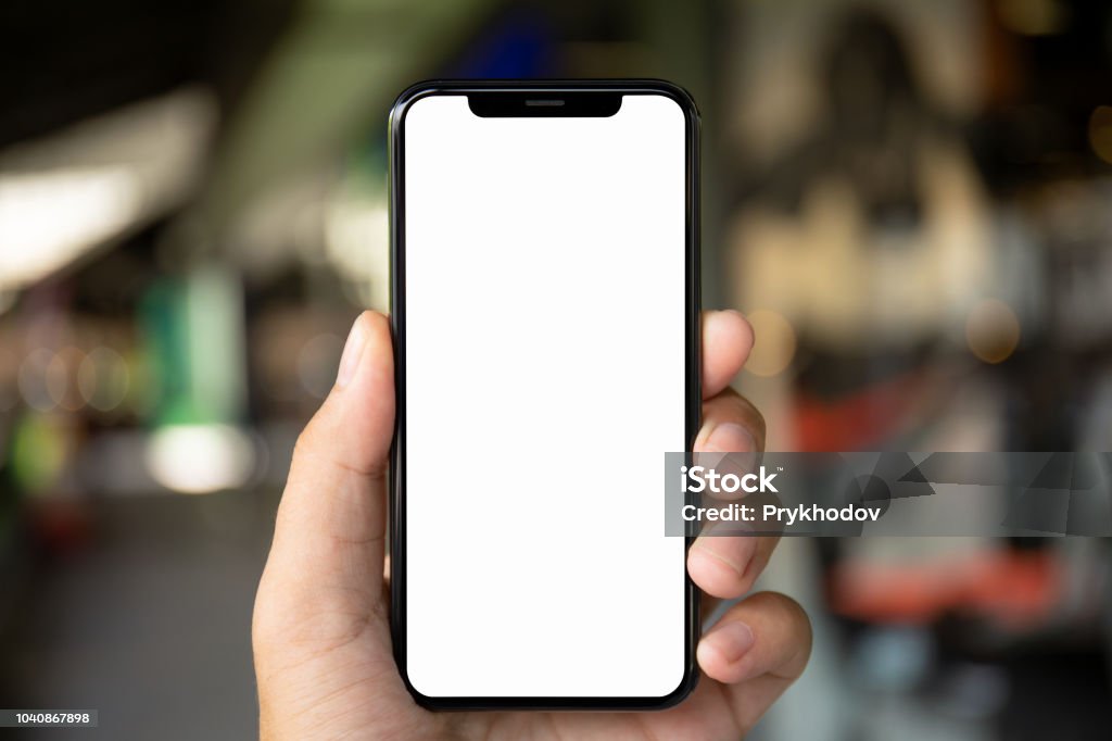 man hand holding phone with isolated screen on background city man hand holding phone with isolated screen on the background of a city street Telephone Stock Photo