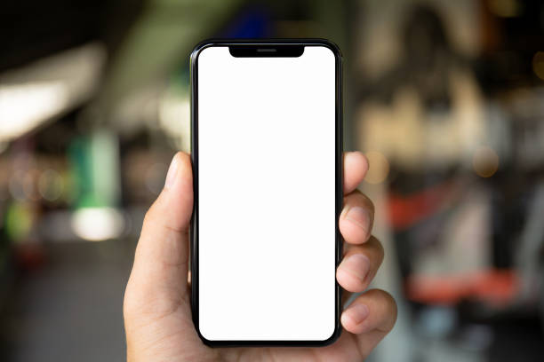 человек стороны, держа телефон с изолированным экраном на фоне города - holding phone стоковые фото и изображения