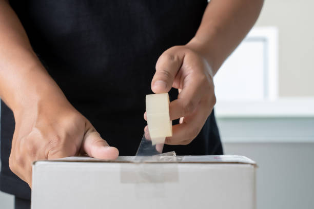 istock man hand transparent  man packing box adhesive tape. 1040869902
