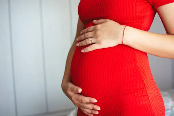 Photo of Pregnant woman holds hands on belly