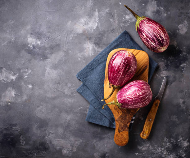 istock Fresh striped purple aubergines on grey background 1040890714