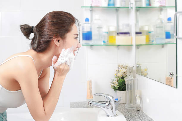 mulher feliz limpa a pele com a espuma de banho. - washing face - fotografias e filmes do acervo