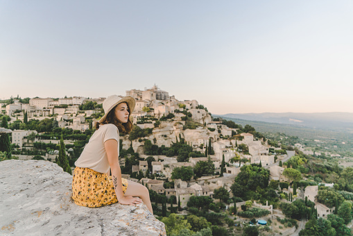 Young Caucasian woman in hat  looking at scenic view  of Gordes village in Provence