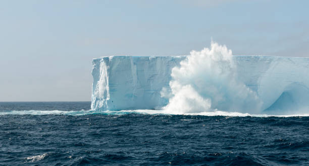 istock Wave crashing and spraying over tabular iceberg, Antarctic Peninsula 1040902144