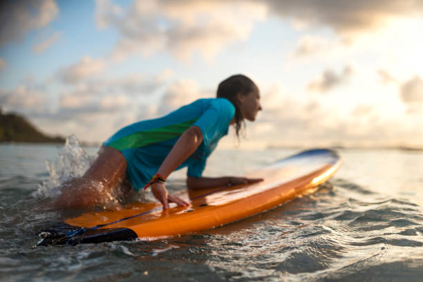 istock Young girl surfing at sunset 1040907152