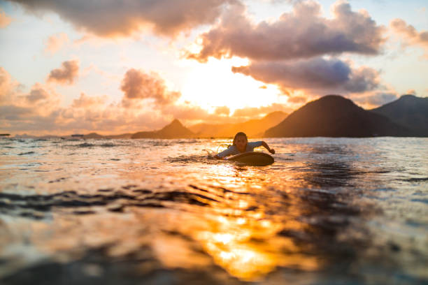 istock Young girl surfing at sunset 1040911026