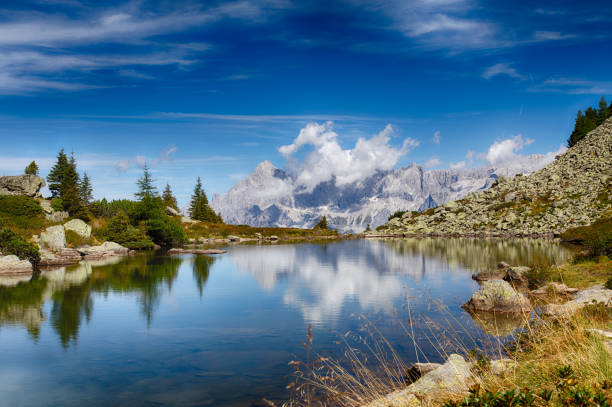 Spiegelsee and Dachstein at Reiteralm in Ennstal Spiegelsee and Dachstein in the background during a beautiful summer day with blue sky. Ennstal in Styria, Austria. dachstein mountains photos stock pictures, royalty-free photos & images