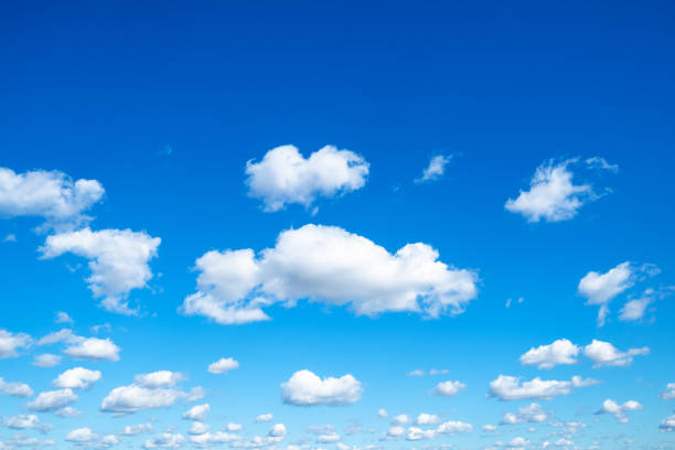 many little fluffy clouds in blue sky in sunny day stock photo