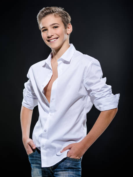 Photo of adorable teenage young happy guy Photo of adorable teenage young happy guy looking at camera. teenager boy haircuts stock pictures, royalty-free photos & images