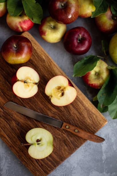 istock Cutting apples on wooden board.  View from the top. 1040920940