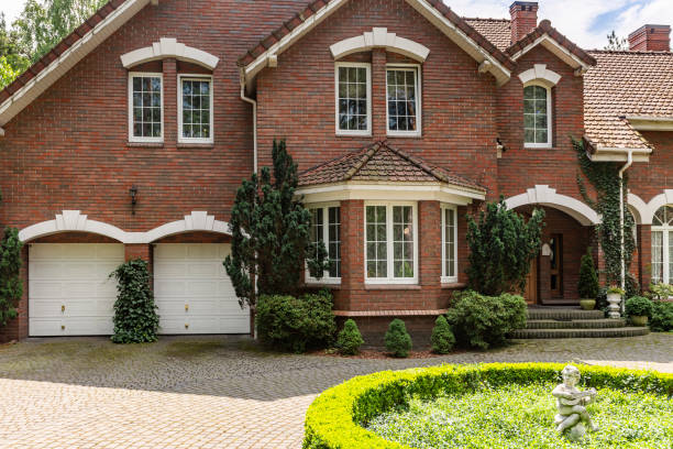 foto real de uma casa de tijolo com uma janela de baía, garagens e redondo jardim na frente da entrada - southern mansion - fotografias e filmes do acervo